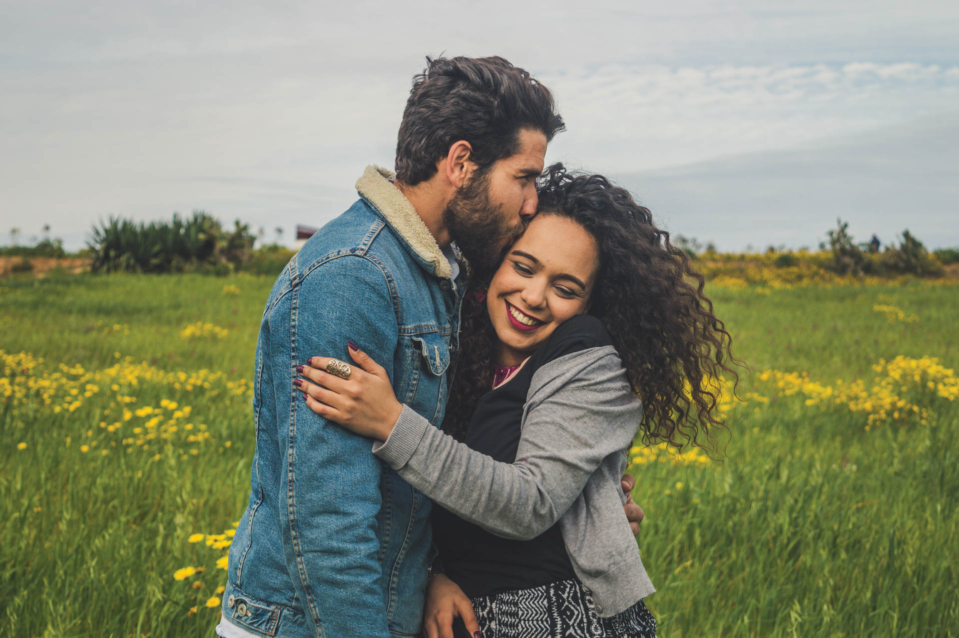 Young couple hugging in a field.