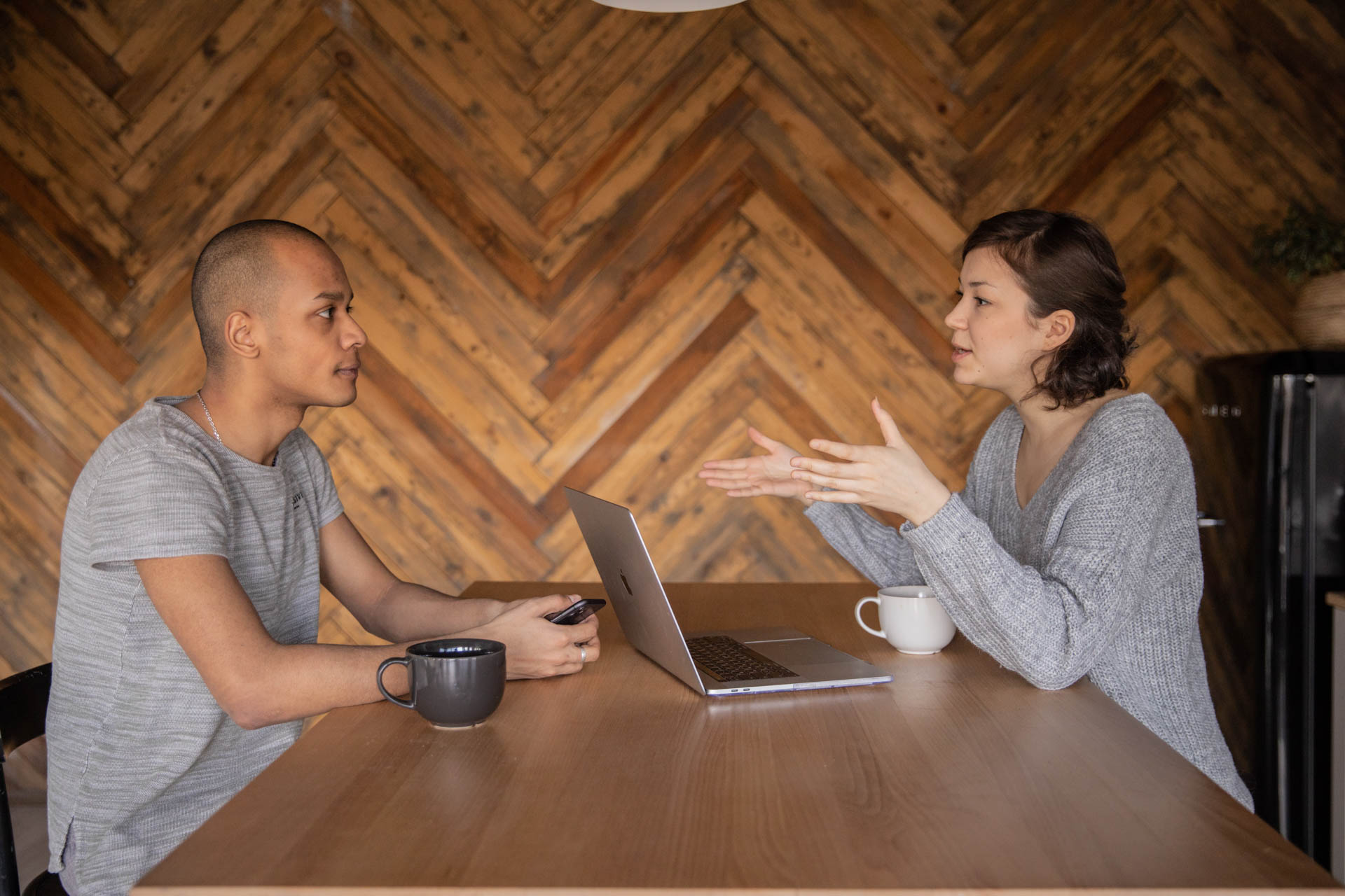 Two people having a discussion at a table.