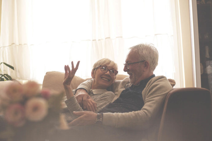 Senior couple resting on sofa,watching tv.