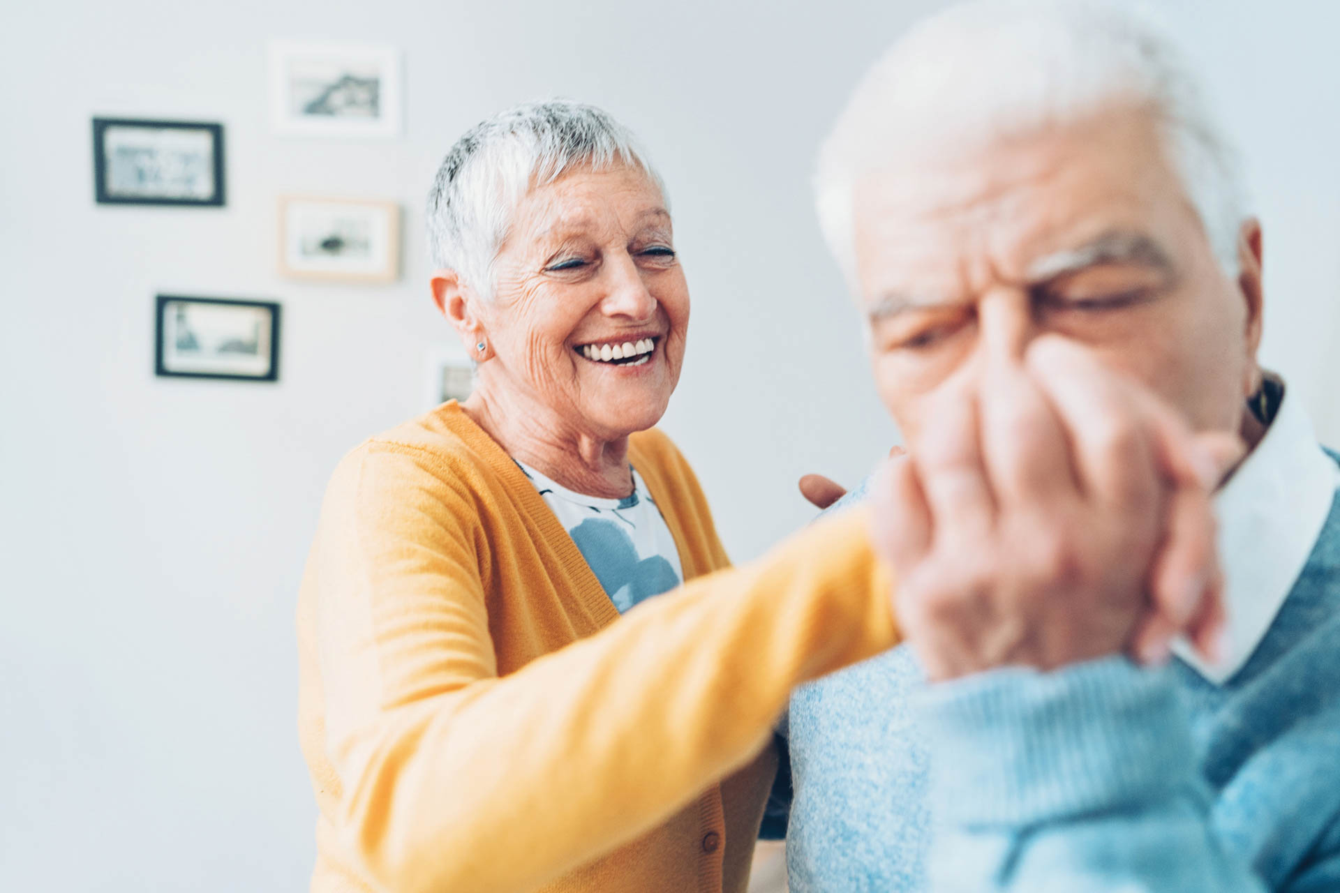 Senior couple dancing at home.