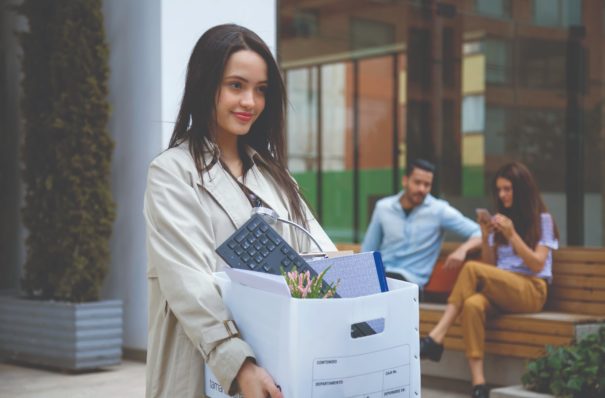 Woman carrying a box of work supplies.