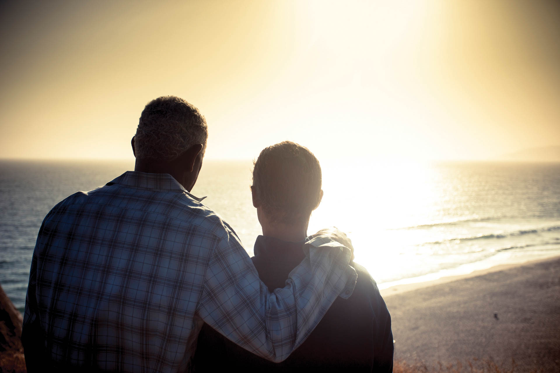 Father and son looking out at the sunset.